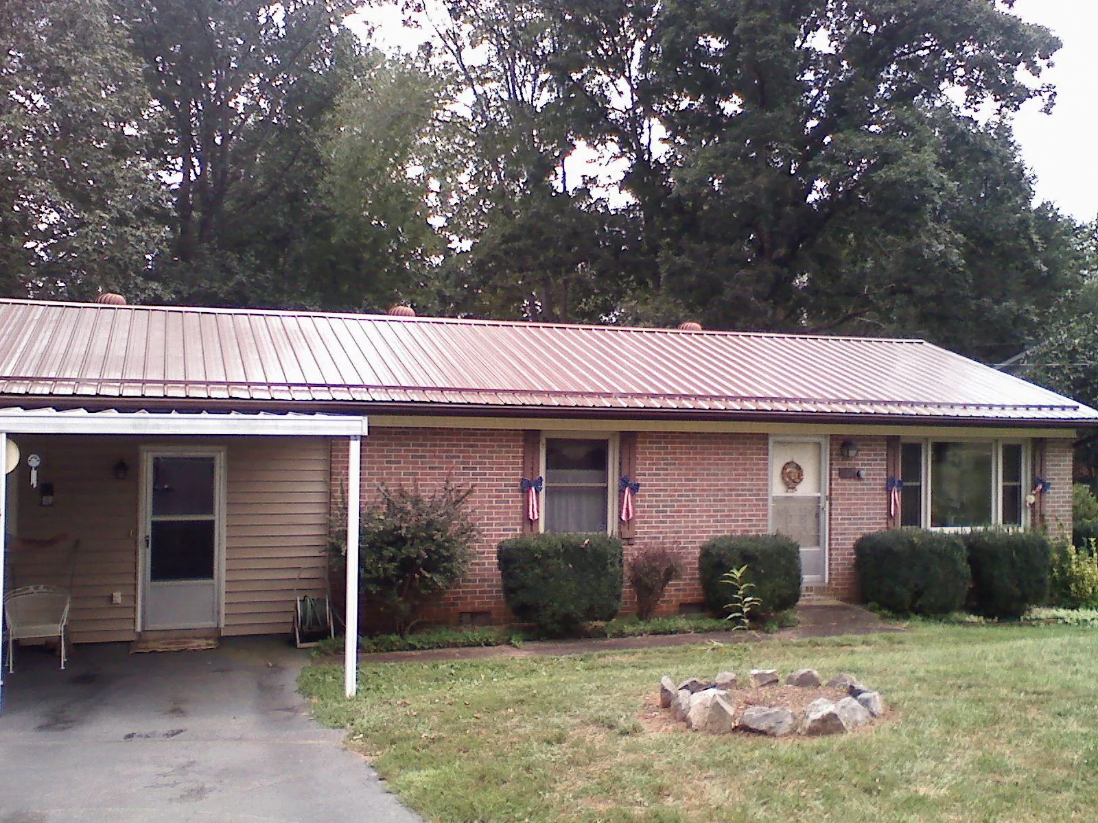 Bronze metal roof and carport on a brick ranch home — Roof Repair work by our crew in Stafford